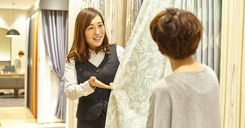 カーテンのご案内をする店員の写真